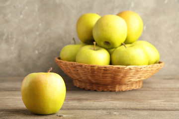 Naklejka na ściany i meble Green apples in the basket on grey wooden background