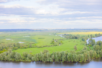 Fototapeta na wymiar greenfield landscape scene with river and cloudy sky