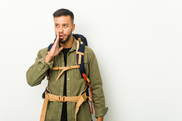 Young south-asian traveller is saying a secret hot braking news and looking aside