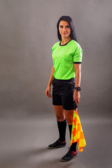 Beautiful Soccer Referee with flag in hand looking at camera and smile