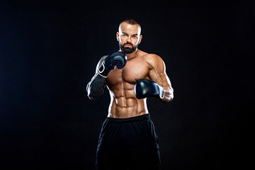 Fototapeta na wymiar Fitness and boxing concept. Boxer, man fighting or posing in gloves on black background. Individual sports recreation.