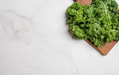 White copy space with cutting board with kale in right corner