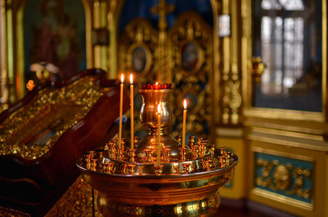  Icon of Jesus in a wooden frame. Candles are burning in the temple near the altar. Temple.