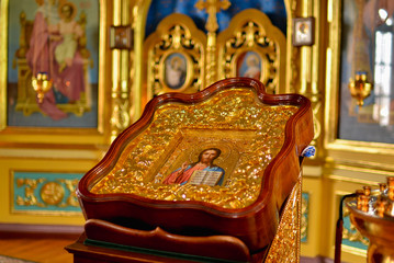 Fototapeta premium Icon of Jesus in a large wooden frame. Temple with golden frescoes.