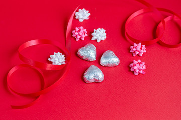 Mother's Day, Women's Day, Valentine's Day or birthday on a red background. Hearts of different colors and candies