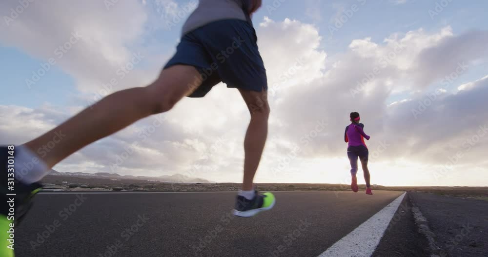 Wall mural Running people low angle view in slow motion of sport fitness people on training run running fast.