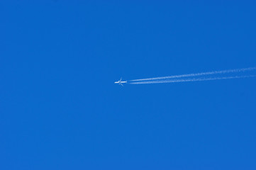 Plane with trace on a clear blue sky