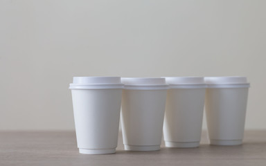 Food. White paper cup cappuccino in beige background
