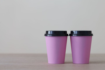Food. Pink paper cup cappuccino in beige background