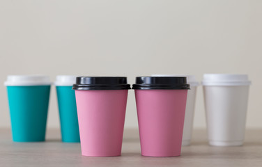 Food. Multi colored paper cup cappuccino in beige background