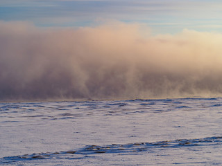 Winter fog over the river in sunset light.