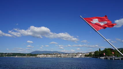 Swiss flag waving over water in Geneva, Switzerland