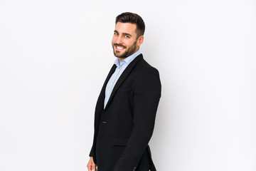 Young caucasian business man against a white background isolated looks aside smiling, cheerful and pleasant.