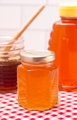 Jars of Raw Organic Honey on a Red and White Table Cloth