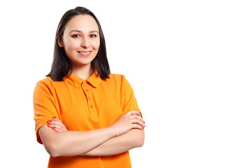 a young woman in an orange Polo shirt with her arms crossed looks at the camera and smiles.