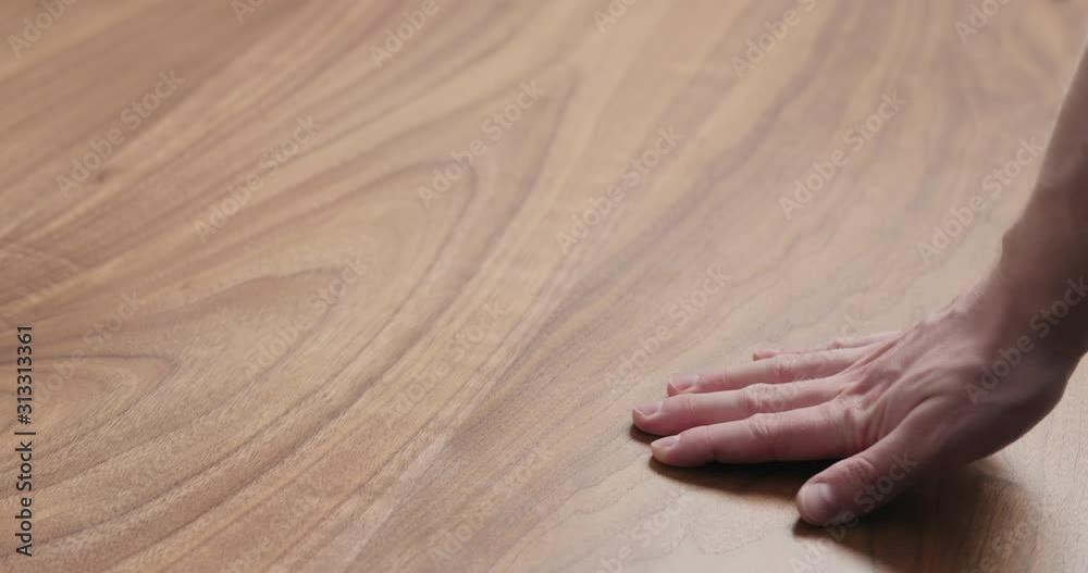 Wall mural Slow motion man hand touches black walnut dining table surface - Wall murals