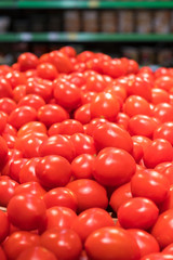 Vegetables are full of vitamins. Fresh and ripe tomatoes in a basket on a supermarket shelf. Ripe tomatoes in a supermarket. vertical photo