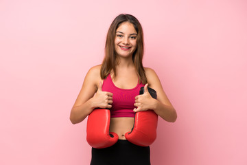 Young sport girl over isolated pink background with boxing gloves