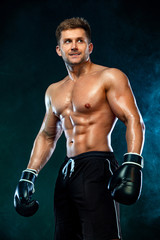 Fototapeta na wymiar Fitness and boxing concept. Boxer, man fighting or posing in gloves on dark background. Individual sports recreation.