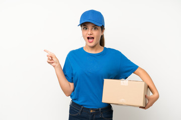 Young delivery girl over isolated white background surprised and pointing finger to the side