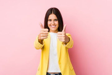 Young business woman with thumbs ups, cheers about something, support and respect concept.