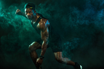 Fototapeta na wymiar Sports men athlete on dark background. Power athletic guy bodybuilder doing fitness training.