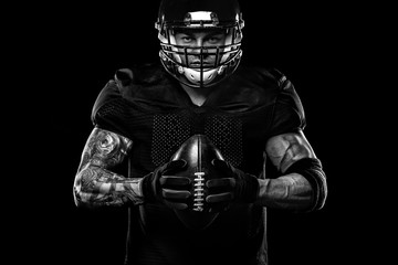 Sport concept. American football sportsman player on black background. Sport concept.