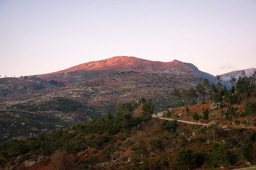 Montanha com estrada iluminada no topo pelo sol