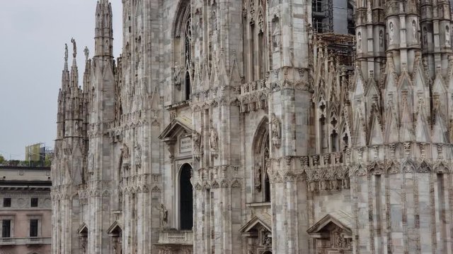Milan, Italy - April, 2019 - Tilt down shot of the southwest corner of the Milan Cathedral (Duomo di Milano).