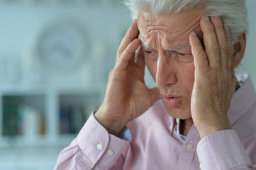 Close up portrait of sad sick senior man with headache