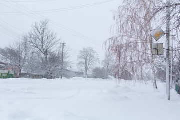 Winter, rural streets are covered with snow. Snow blizzard