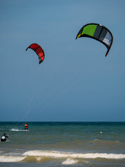 Two colorful Kite Surfer from behind heading towards open seas