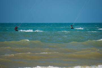 Two chasing Kite Surfer from behind heading towards open seas