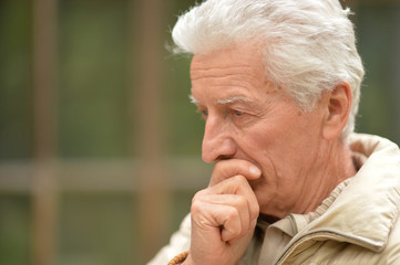 Close up portrait of serious senior man thinking 