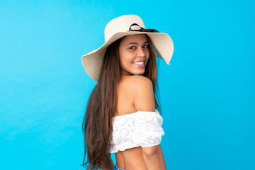 Young woman in summer holidays over isolated blue background