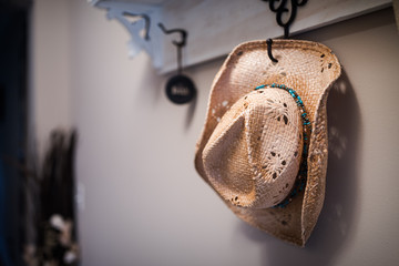 Woven cowgirl hat hanging on a coat rack