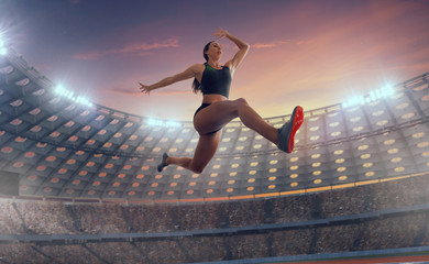 Athlete woman doing a long jump at the sports championship.