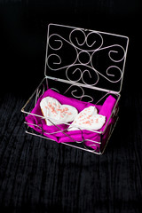Cookies in the form of heart lies in a casket with pink cloth