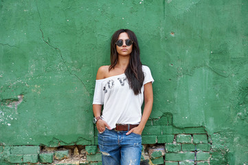 Outdoor street portrait of stylish woman in sunglasses and casual clothes