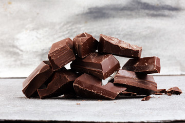 Dark chocolate stack, chips and powder with chocolate bars and block