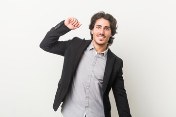 Young business man against a white background stretching arms, relaxed position.