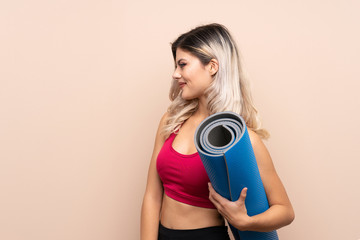 Fototapeta premium Teenager sport girl over isolated background with a mat