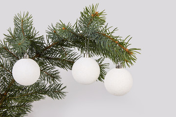 Fototapeta na wymiar Christmas white glitter bauble balls and evergreen spruce branch, on white background