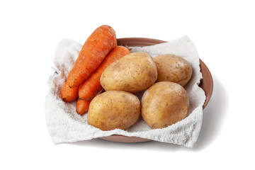 boiled potatoes and carrots on a towel in a plate on the white background