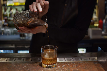 Pouring prepared cocktail into glass