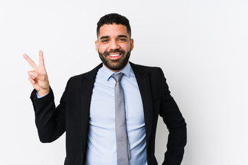 Young latin business woman against a white background isolated joyful and carefree showing a peace symbol with fingers.