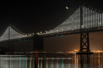 Fototapeta na wymiar View of Half Moon Over the San Francisco Oakland Bridge at Night