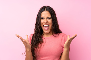 Young woman over isolated pink background unhappy and frustrated with something