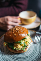 Veggie burger with poached egg and sorrel in a curd bun. healthy breakfast concept in the style of a lifestyle.