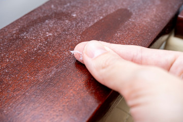 A finger swiping dust from furniture, dusty home concept